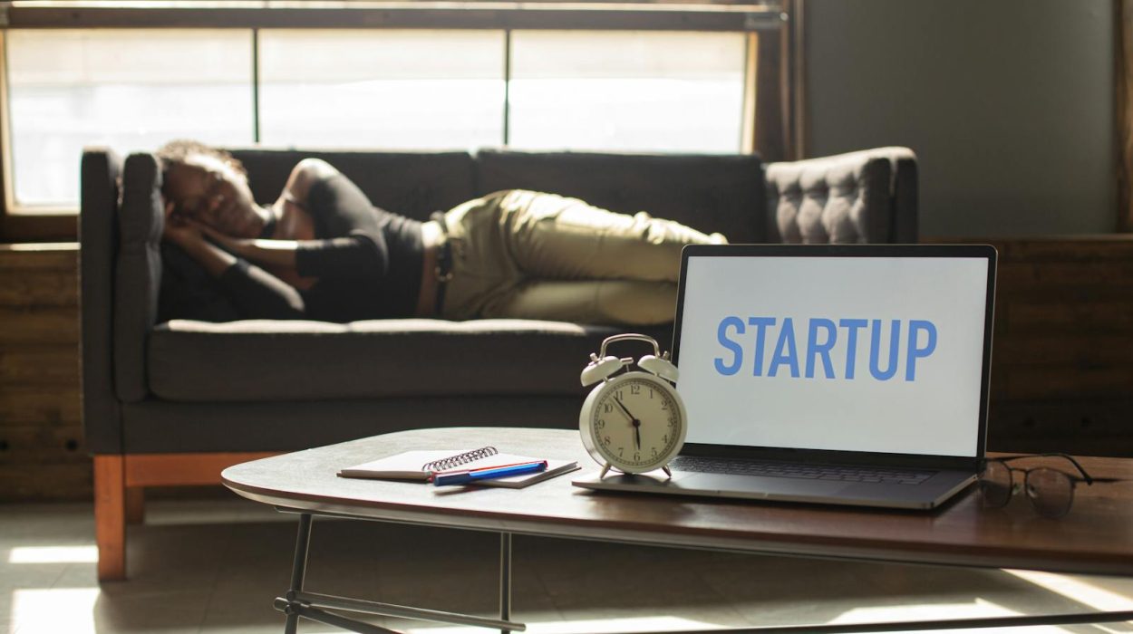 A woman lies on a sofa while a laptop displays 'STARTUP,' capturing a workspace vibe.